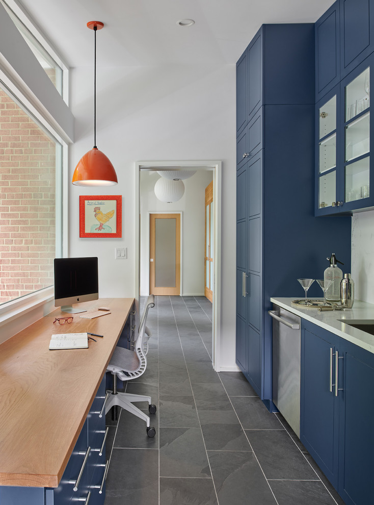 Immagine di un piccolo ufficio moderno con pareti bianche, pavimento in ardesia, scrivania incassata e soffitto a volta