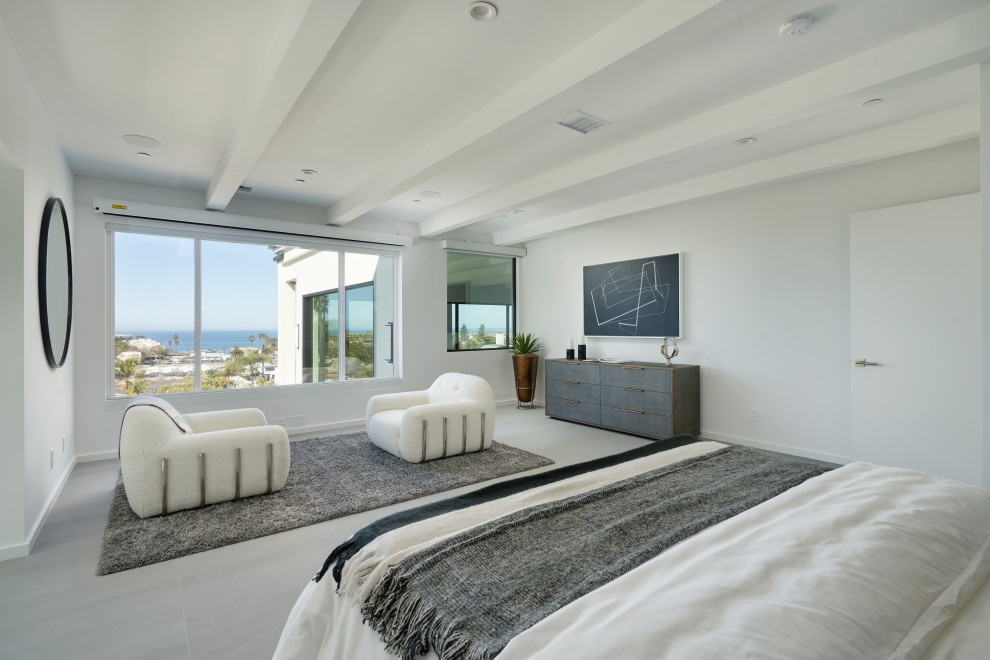 Large modern master bedroom in San Diego with white walls, concrete floors, no fireplace, grey floor and coffered.