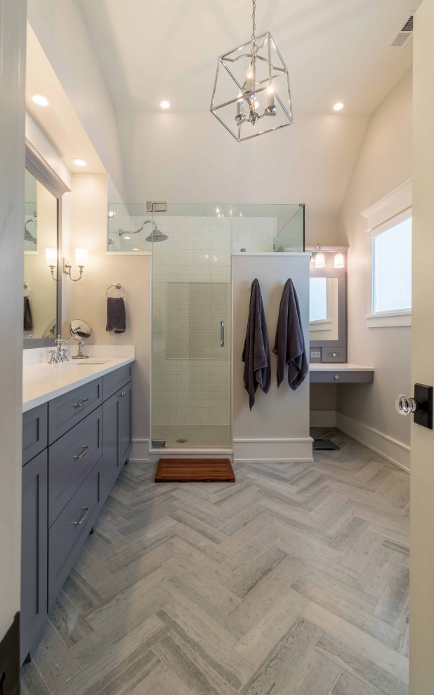 Photo of a large country master bathroom in Chicago with shaker cabinets, blue cabinets, an alcove shower, a one-piece toilet, white tile, limestone, limestone floors, an integrated sink, solid surface benchtops, blue floor, a sliding shower screen, white benchtops, a shower seat, a single vanity, a freestanding vanity, wallpaper, wallpaper and white walls.