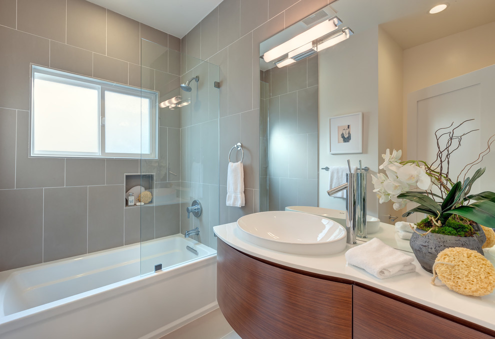 Design ideas for a mid-sized contemporary wet room bathroom in Other with flat-panel cabinets, medium wood cabinets, an alcove tub, gray tile, porcelain tile, beige walls, porcelain floors, a vessel sink, wood benchtops, beige floor and white benchtops.