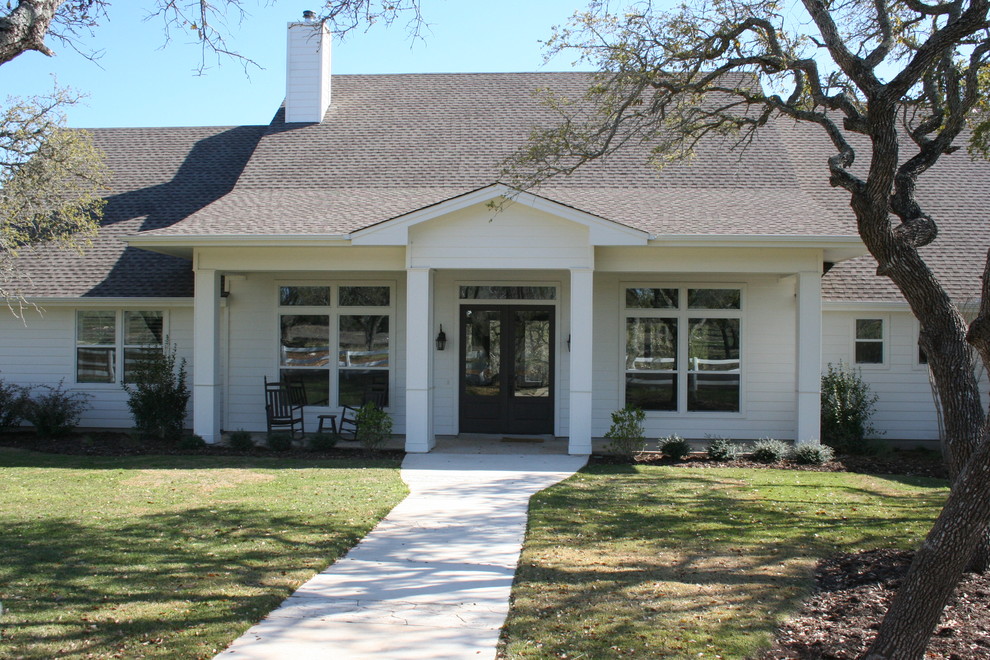 This is an example of a country two-storey white exterior in Austin.
