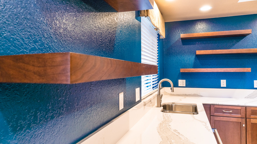 Inspiration for a large transitional l-shaped laminate floor eat-in kitchen remodel in Seattle with an undermount sink, recessed-panel cabinets, dark wood cabinets, quartz countertops, stainless steel appliances and an island