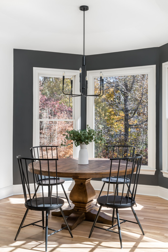 Mid-sized transitional light wood floor dining room photo in Atlanta with black walls