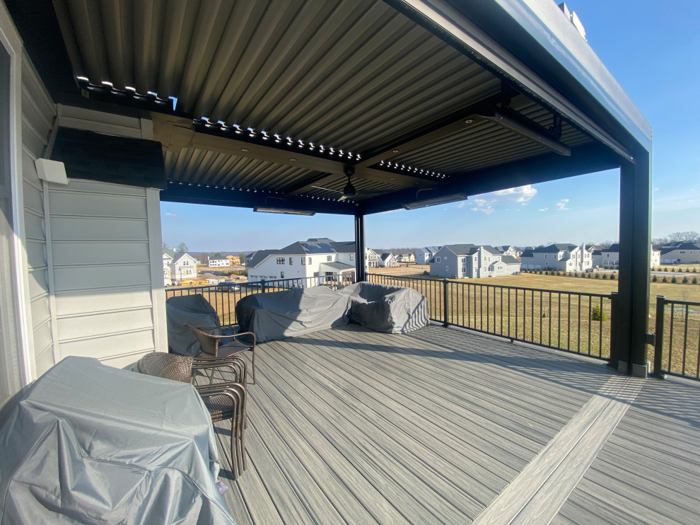 Foto de terraza actual grande en patio trasero con privacidad, pérgola y barandilla de metal
