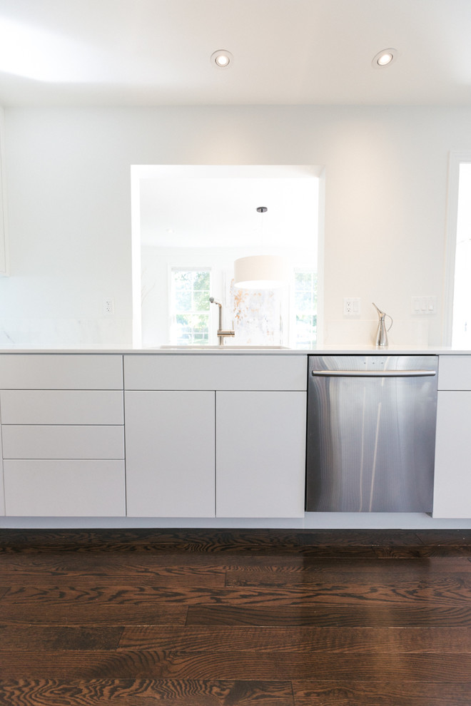 Inspiration for a mid-sized scandinavian galley eat-in kitchen in Toronto with an undermount sink, flat-panel cabinets, white cabinets, white splashback, marble splashback, stainless steel appliances, dark hardwood floors and brown floor.