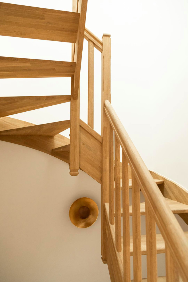 Inspiration for a mid-sized wood curved staircase in Paris with wood risers and wood railing.