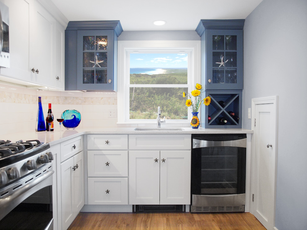 Large beach style l-shaped eat-in kitchen in Boston with shaker cabinets, blue cabinets, white splashback, stainless steel appliances, an undermount sink, quartz benchtops, subway tile splashback and with island.