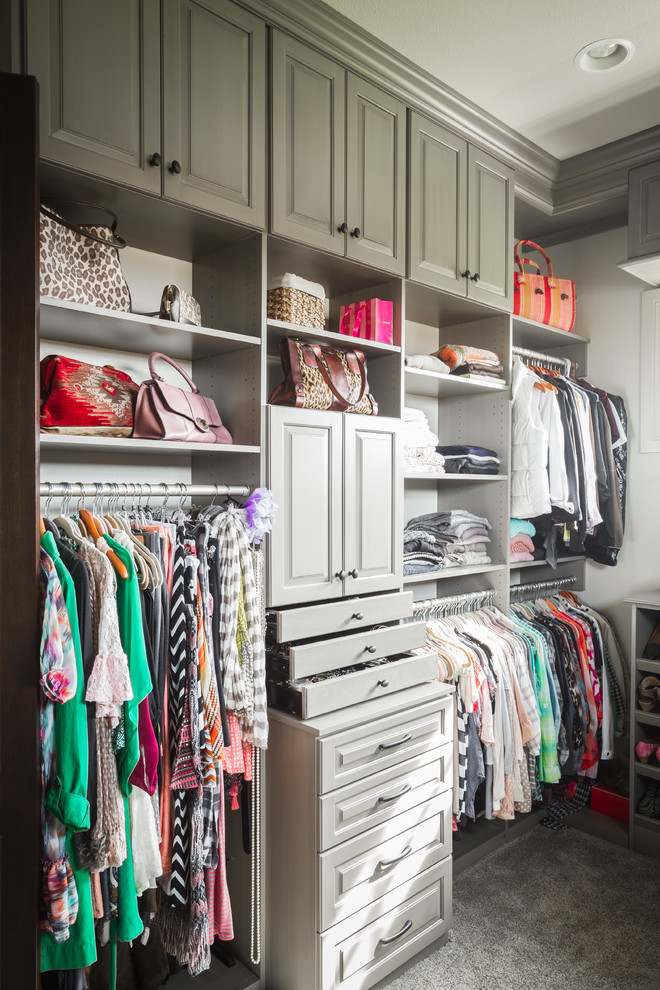 Example of a transitional gender-neutral carpeted walk-in closet design with raised-panel cabinets and gray cabinets