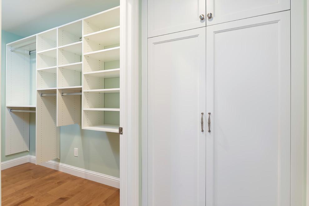 Design ideas for a mid-sized transitional gender-neutral walk-in wardrobe in San Francisco with recessed-panel cabinets, white cabinets, medium hardwood floors and brown floor.