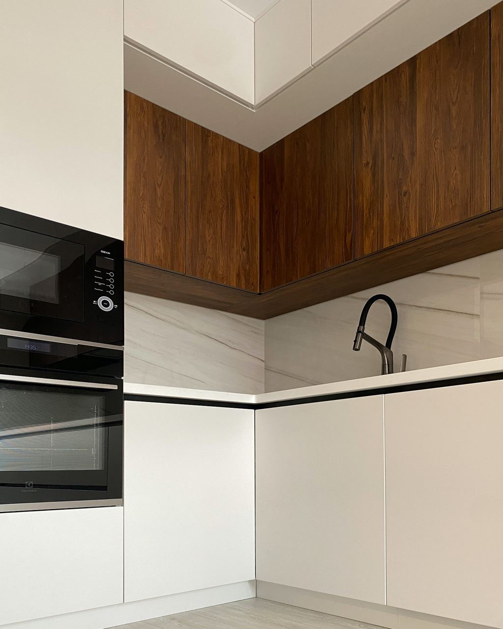 Светлая встроенная угловая кухня с однотонными матовыми фасадами