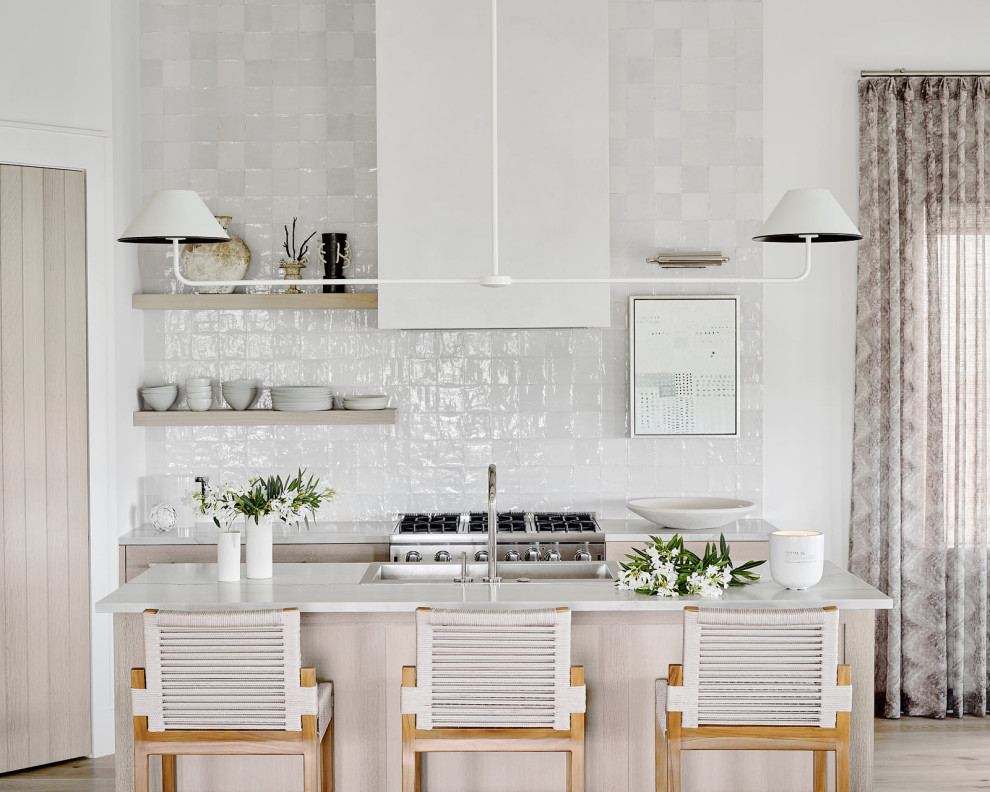 Beach Bungalow - Inspiration for a huge coastal single-wall light wood floor and beige floor eat-in kitchen remodel in Houston with a drop-in sink, flat-panel cabinets, light wood cabinets, white backsplash, stainless steel appliances, an island and white countertops