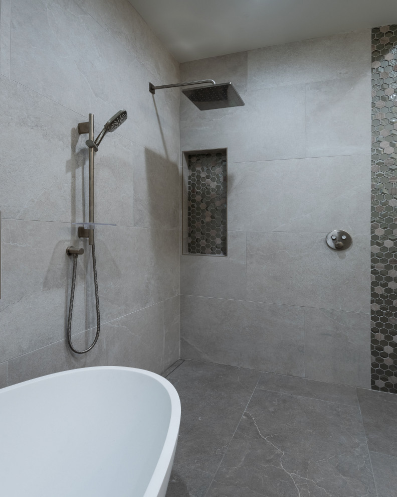 Пример оригинального дизайна: главная ванная комната среднего размера в современном стиле с плоскими фасадами, серыми фасадами, отдельно стоящей ванной, душем без бортиков, раздельным унитазом, серой плиткой, каменной плиткой, серыми стенами, полом из цементной плитки, врезной раковиной, столешницей из искусственного кварца, серым полом, открытым душем, белой столешницей, нишей, тумбой под две раковины и встроенной тумбой