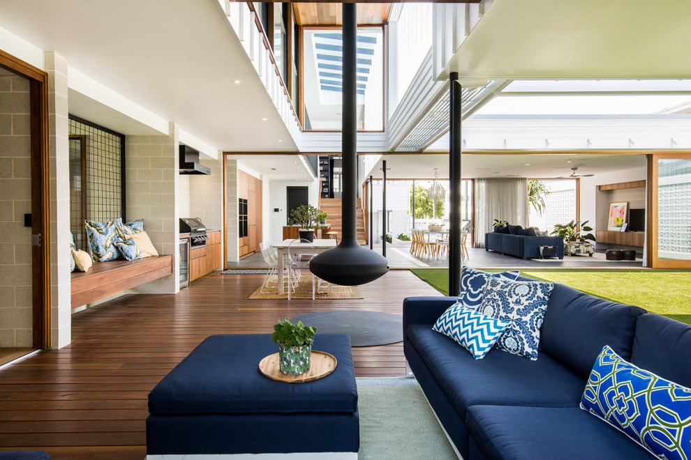 Design ideas for a contemporary deck in Brisbane with with fireplace and a roof extension.
