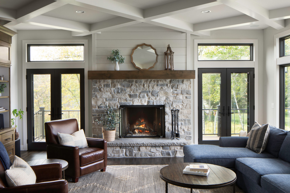 Photo of a mid-sized transitional open concept family room in Milwaukee with grey walls, dark hardwood floors, a standard fireplace, a stone fireplace surround, a built-in media wall, brown floor and coffered.