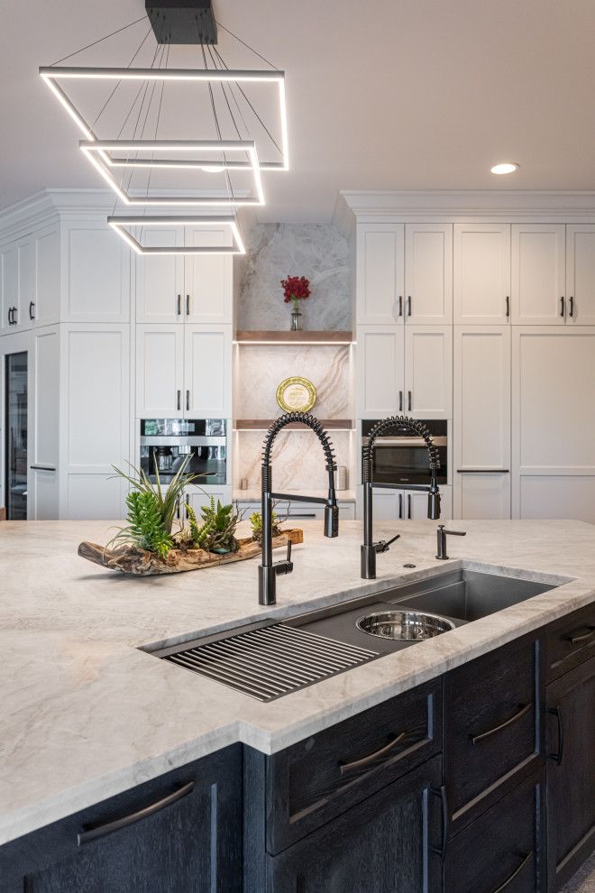 Large transitional medium tone wood floor and brown floor open concept kitchen photo with a double-bowl sink, flat-panel cabinets, white cabinets, quartzite countertops, beige backsplash, stainless steel appliances, an island and beige countertops