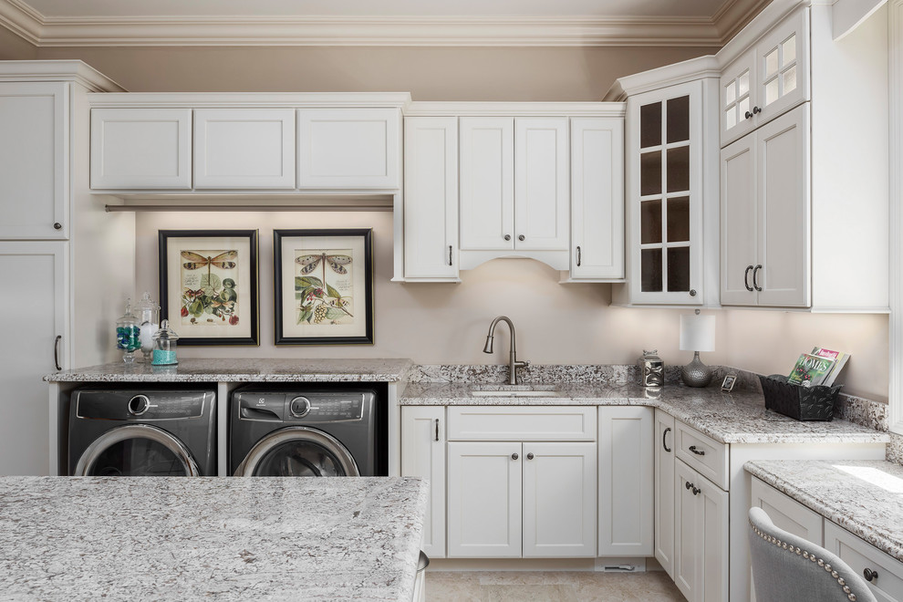 Inspiration for a large traditional u-shaped utility room in St Louis with flat-panel cabinets, white cabinets, granite benchtops, a side-by-side washer and dryer and beige floor.