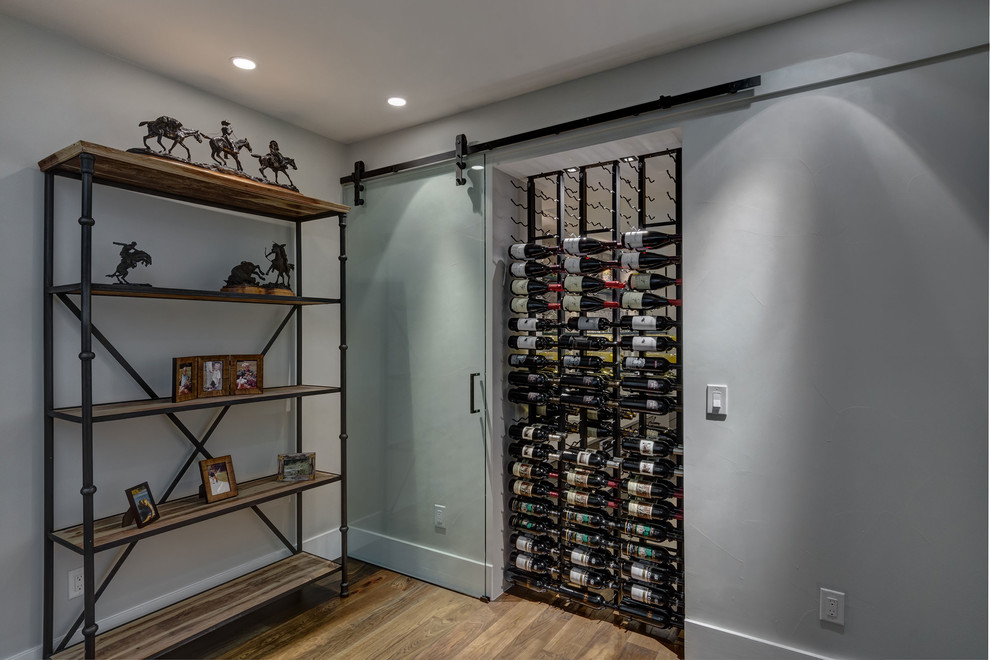 Inspiration for a large contemporary wine cellar in Denver with light hardwood floors and brown floor.