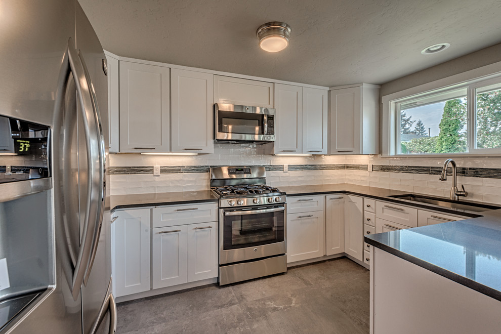 This is an example of a small scandinavian u-shaped eat-in kitchen in Seattle with an undermount sink, shaker cabinets, white cabinets, quartz benchtops, white splashback, ceramic splashback, stainless steel appliances, concrete floors and no island.