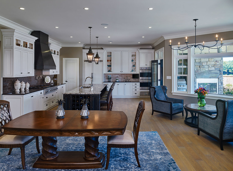 Inspiration for a mid-sized transitional single-wall light wood floor eat-in kitchen remodel in Philadelphia with a drop-in sink, recessed-panel cabinets, light wood cabinets, granite countertops, metallic backsplash, ceramic backsplash, stainless steel appliances and an island