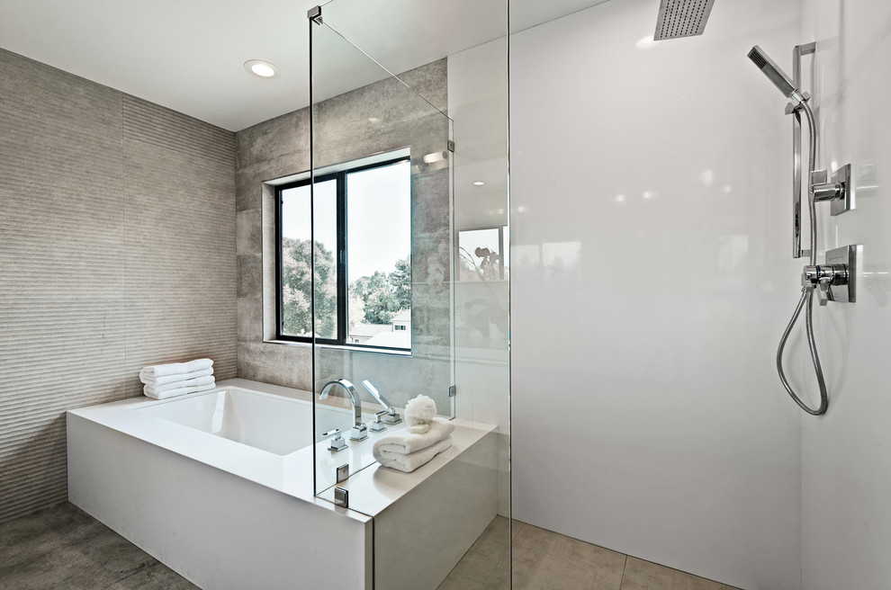 This is an example of a large contemporary master bathroom in San Francisco with an undermount tub, a curbless shower, gray tile, white walls, an open shower, flat-panel cabinets, white cabinets, an undermount sink, solid surface benchtops, brown floor and white benchtops.