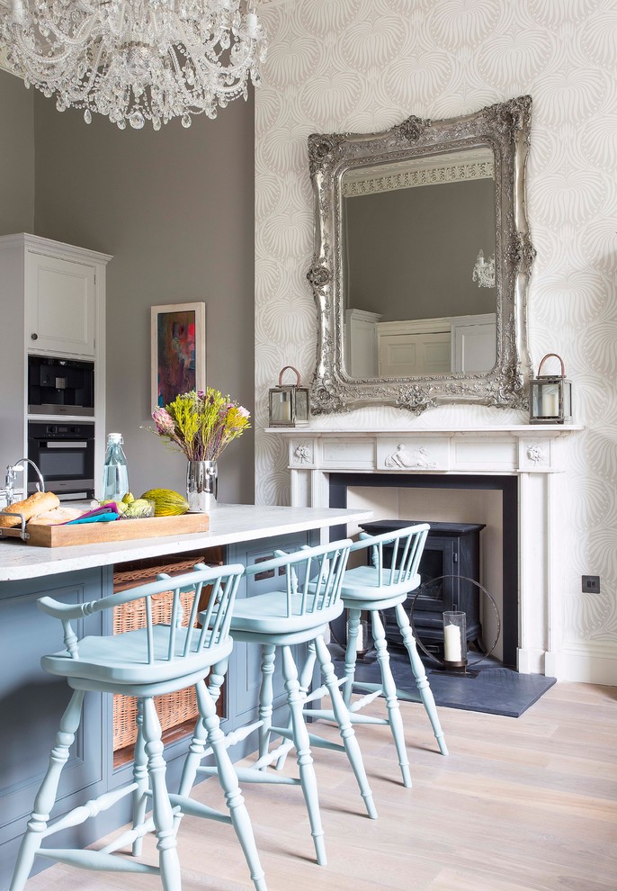 Mid-sized traditional kitchen/dining combo in Edinburgh with medium hardwood floors, grey walls, a wood stove and a plaster fireplace surround.