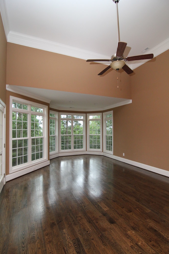Large transitional master bedroom in Raleigh with beige walls and dark hardwood floors.