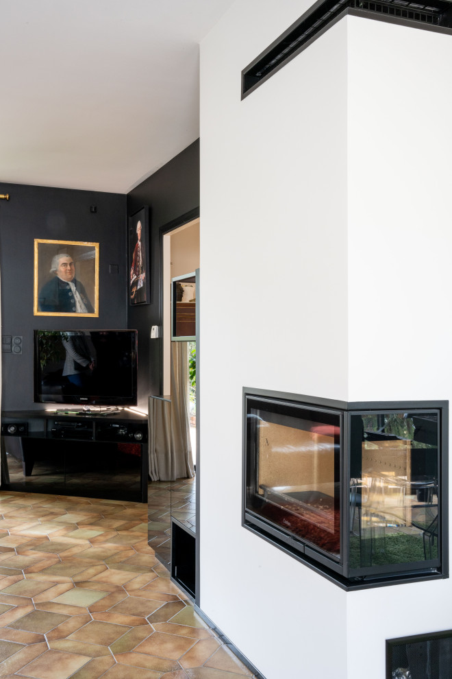 Стильный дизайн: открытая гостиная комната среднего размера в классическом стиле с с книжными шкафами и полками, черными стенами и телевизором в углу - последний тренд
