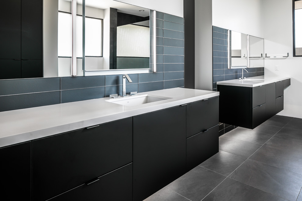 This is an example of a mid-sized contemporary master bathroom in Phoenix with flat-panel cabinets, black cabinets, a freestanding tub, an open shower, blue tile, glass tile, white walls, porcelain floors, an undermount sink, engineered quartz benchtops, grey floor, white benchtops and a hinged shower door.