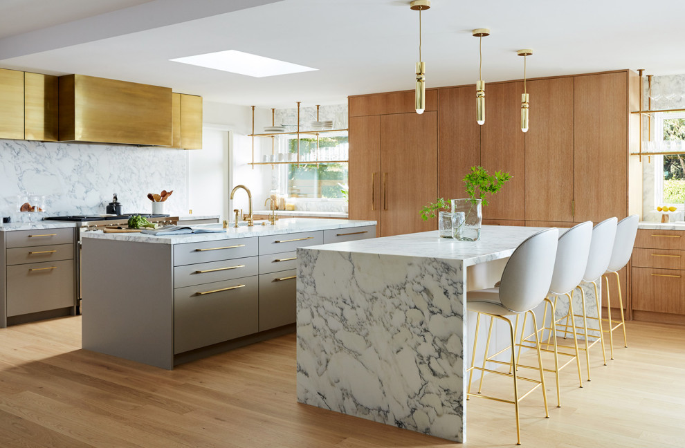 Foto di una cucina abitabile minimalista con pavimento in legno massello medio, 2 o più isole e pavimento beige
