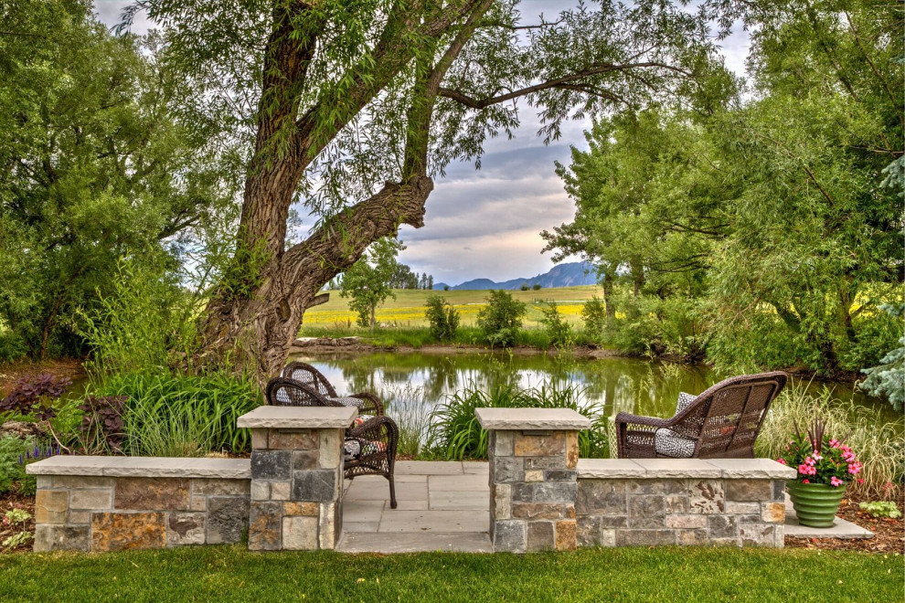 Großer, Halbschattiger Landhausstil Gartenteich im Sommer, hinter dem Haus mit Natursteinplatten und Steinzaun in Denver