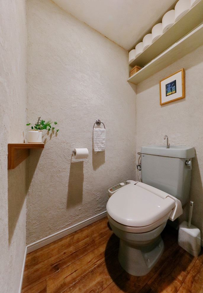 This is an example of an asian powder room in Other with white walls, medium hardwood floors and brown floor.