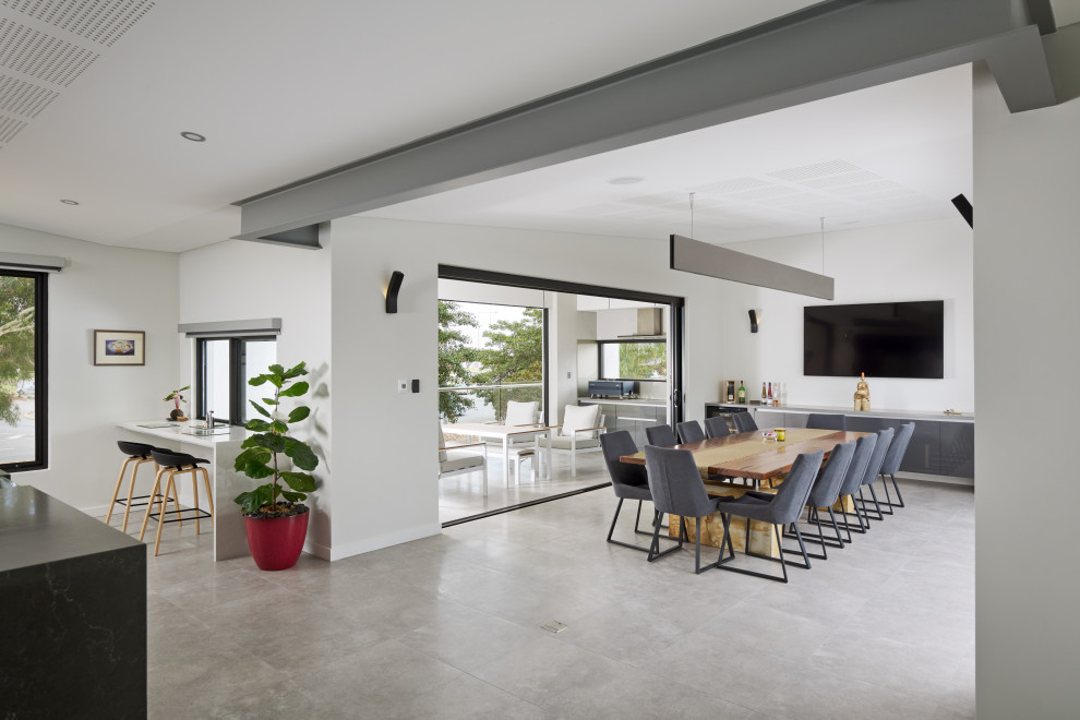 Inspiration pour une salle à manger ouverte sur la cuisine minimaliste de taille moyenne avec un mur gris, un sol en carrelage de porcelaine, un sol gris et poutres apparentes.