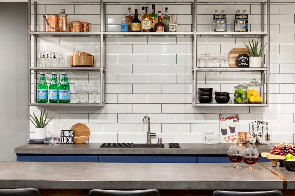 Design ideas for a modern u-shaped seated home bar in Minneapolis with an undermount sink, shaker cabinets, blue cabinets, concrete benchtops, white splashback, ceramic splashback, porcelain floors, grey floor and grey benchtop.