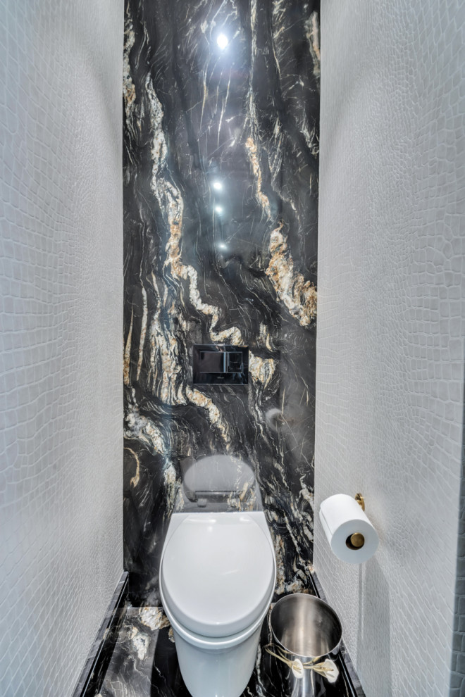 Inspiration for an expansive traditional powder room in New York with furniture-like cabinets, black cabinets, a wall-mount toilet, black tile, marble, beige walls, marble floors, a wall-mount sink, quartzite benchtops, black floor, black benchtops and a floating vanity.
