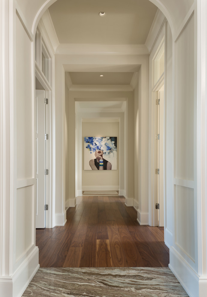 This is an example of a large transitional hallway in Miami with beige walls, medium hardwood floors and brown floor.