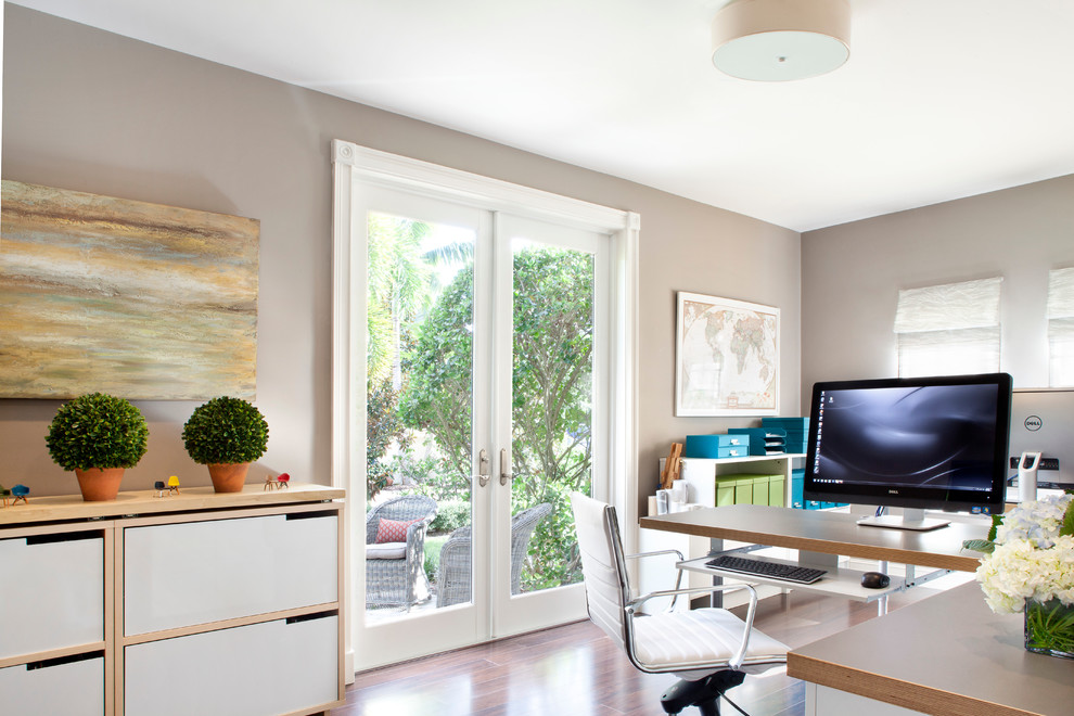 Study room - mid-sized transitional built-in desk dark wood floor study room idea in Miami with beige walls