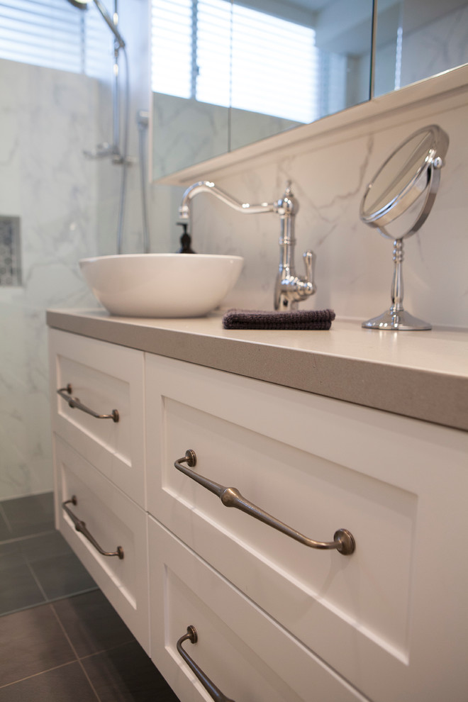 Inspiration for a transitional master bathroom in Auckland with shaker cabinets, white cabinets, a wall-mount toilet, multi-coloured tile, mosaic tile, multi-coloured walls, porcelain floors, a vessel sink and engineered quartz benchtops.
