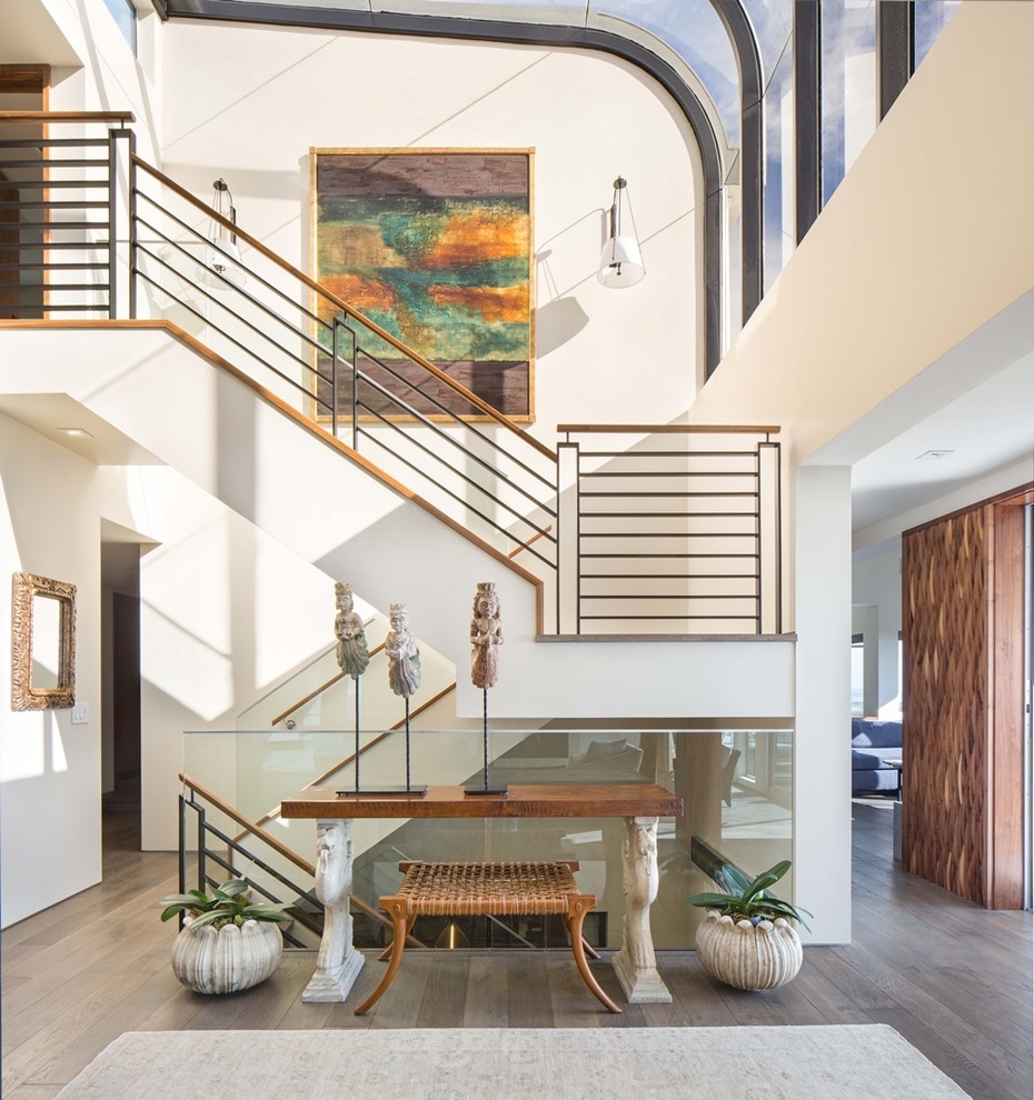 Contemporary foyer in Orange County with white walls, brown floor and light hardwood floors.