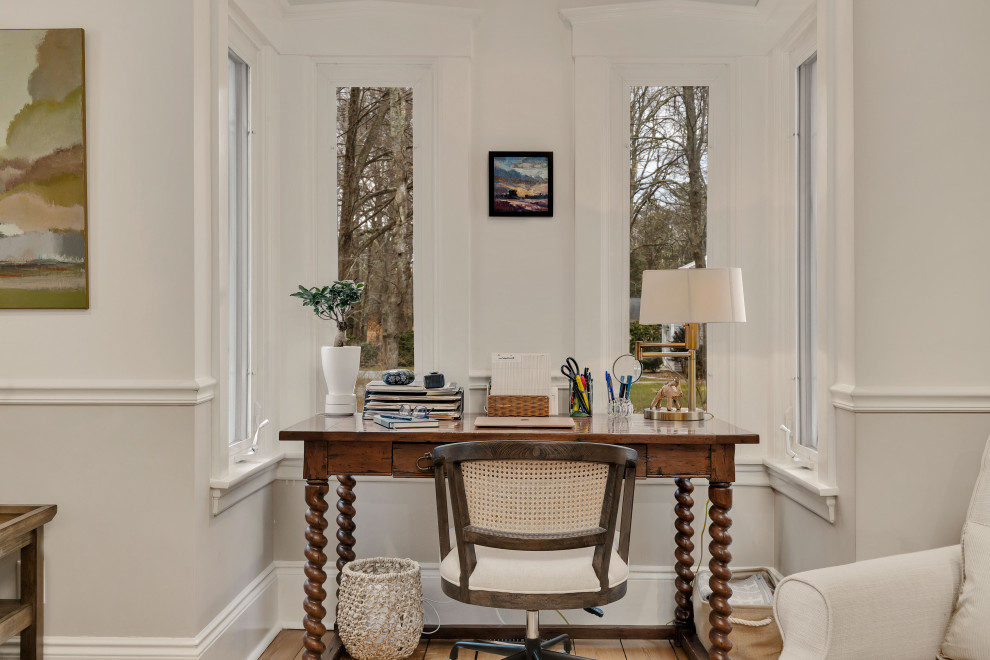 Example of a mid-sized farmhouse freestanding desk light wood floor and brown floor study room design in Boston with beige walls, a standard fireplace and a stone fireplace