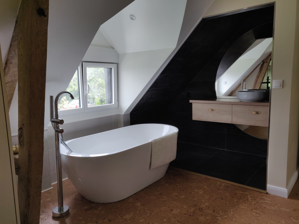 Exempel på ett stort modernt en-suite badrum, med luckor med profilerade fronter, skåp i ljust trä, ett platsbyggt badkar, grå kakel, keramikplattor, grå väggar, korkgolv, ett nedsänkt handfat och träbänkskiva