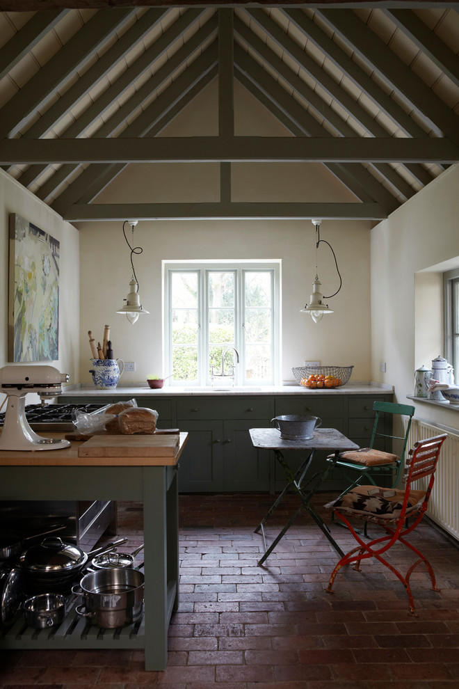Inspiration for a mid-sized transitional l-shaped open plan kitchen in Dorset with a drop-in sink, recessed-panel cabinets, green cabinets, marble benchtops, coloured appliances, brick floors and with island.