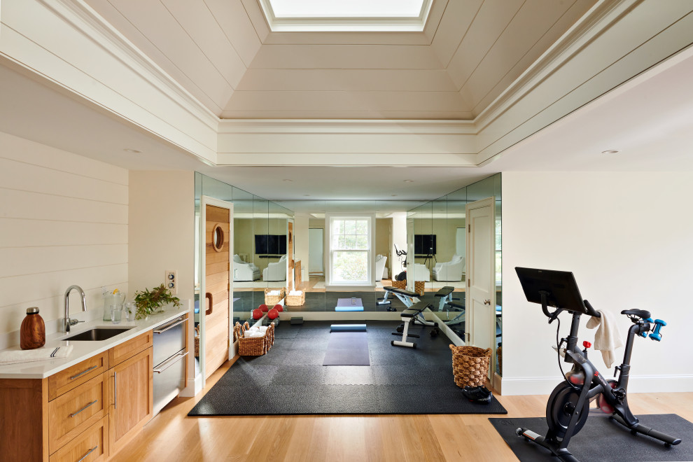 Design ideas for a beach style home gym in Boston with vaulted and light hardwood floors.