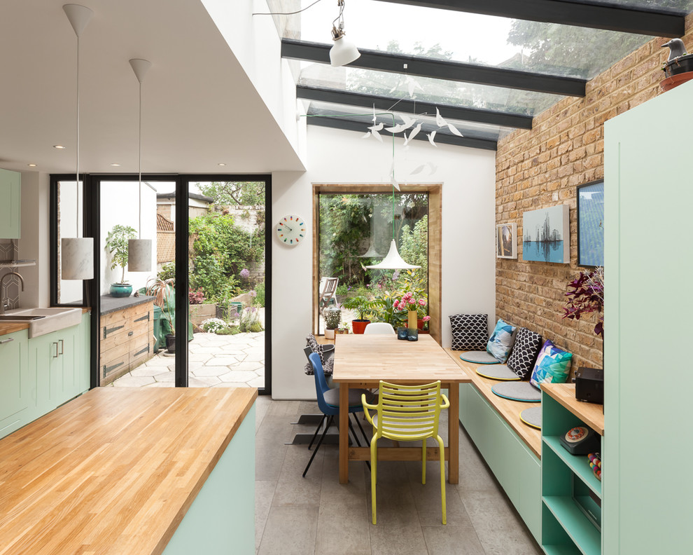 This is an example of a mid-sized eclectic kitchen/dining combo in London with concrete floors and grey floor.