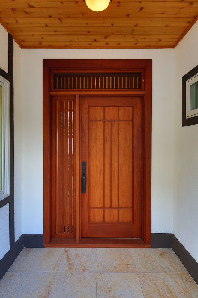 This is an example of an asian front door in Hawaii with white walls, porcelain floors, a single front door and a medium wood front door.