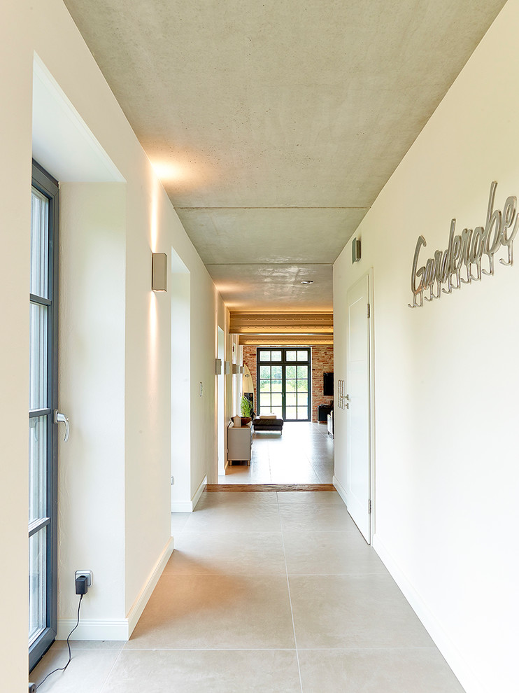 Large industrial hallway in Hamburg with white walls, porcelain floors and beige floor.