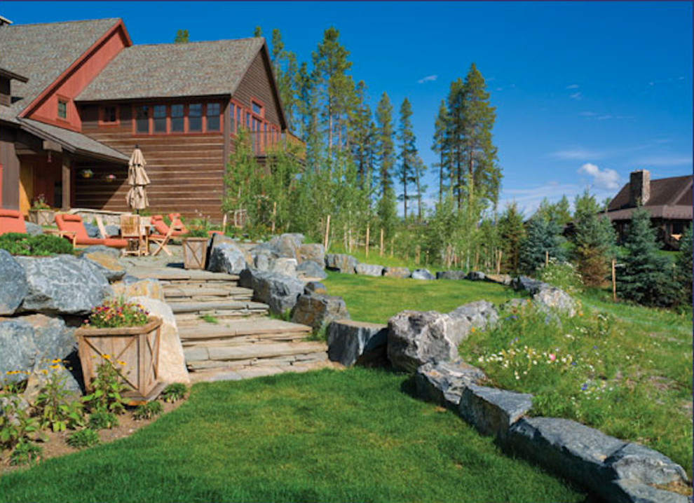 Photo of a mid-sized rustic full sun backyard stone landscaping in Denver for summer.