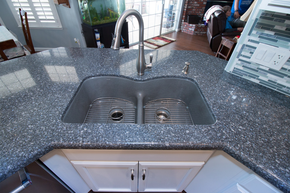 Open concept kitchen - mid-sized transitional u-shaped porcelain tile and brown floor open concept kitchen idea with an undermount sink, recessed-panel cabinets, white cabinets, quartz countertops, blue backsplash, mosaic tile backsplash, stainless steel appliances and blue countertops