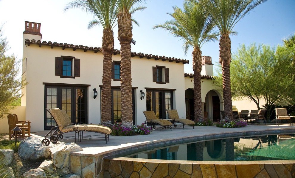 Design ideas for a mediterranean stucco exterior in Los Angeles with a tile roof.