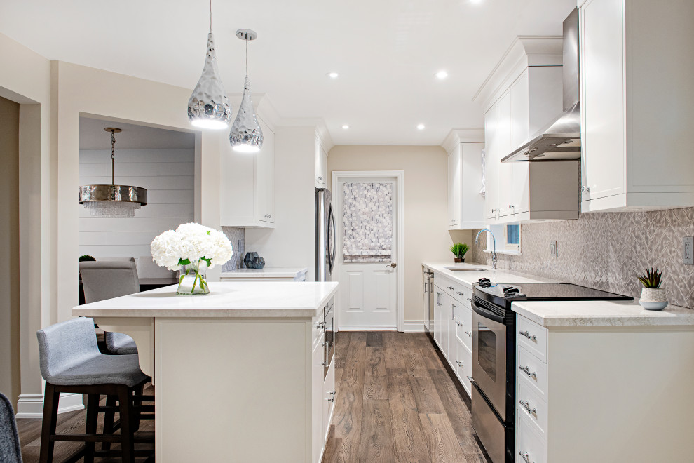 Mid-sized transitional single-wall dark wood floor and brown floor eat-in kitchen photo in Toronto with a double-bowl sink, flat-panel cabinets, white cabinets, quartz countertops, beige backsplash, porcelain backsplash, stainless steel appliances, an island and white countertops