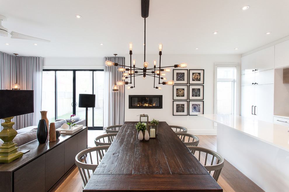 Inspiration for a mid-sized contemporary open plan dining in Ottawa with white walls, light hardwood floors, a ribbon fireplace and beige floor.